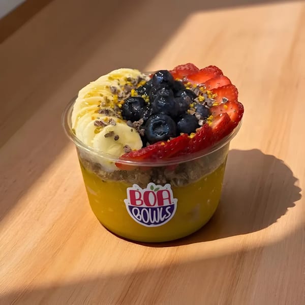A Boa Bowls acai bowl with bananas, blueberries, strawberries, granola, and bee pollen.